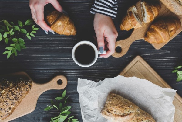 crop-hands-holding-coffee-croissant.jpg